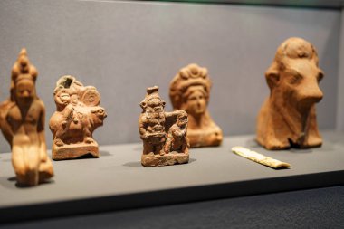 Çeşitli terracotta heykelcikleri, antik zanaatkarlık sergilenen bir müze sergisinde sergileniyor. Heykeller, kültür mirası ve sanatını yansıtan çeşitli figürleri temsil ediyor..
