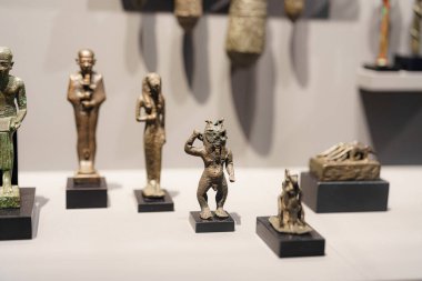 Çeşitli antik heykelcikler bir müze vitrininde duruyor, karmaşık tasarımlar ve işçiliğin altını çiziyorlar. Her parça kültürel tarihin eşsiz bir yönünü yansıtıyor..