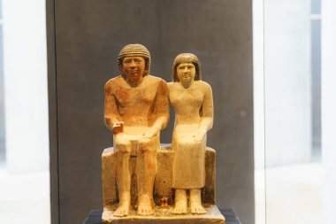 Antik Mısır 'dan bir adam ve bir kadın yan yana oturuyordu. Giysilerinin ve saç stillerinin detaylarını yakalıyor ve tarihsel önemlerini vurguluyor..