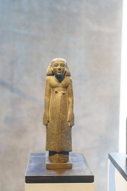 Bu antik taş heykel düz çizgileri ve sakin bir ifadesi olan bir figüre sahiptir. Çağdaş bir müzede, yumuşak doğal ışıkla aydınlatılmış bir kaidede sergilenir..