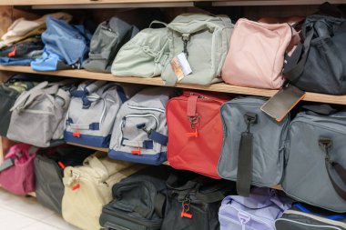 Spor çantaları ve çantalar ahşap perakende raflarında güzelce sergileniyor. Farklı renkler ve boyutlarda, bazılarının etiketleri var..