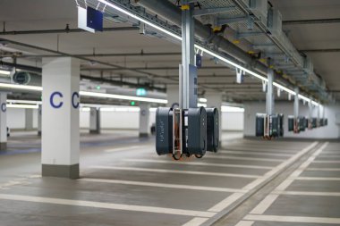 Bu yeraltı otoparkında elektrikli araçlar için çoklu otomatik şarj istasyonları var. Parlak ışıklandırma ve açık tabela geniş alanda navigasyonu artırır.