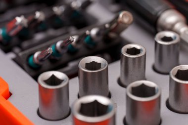 Çeşitli metal aletler ve soketler, parlaklıklarını ve hassasiyetlerini gösteren bir alet kutusunda düzenlenir. Bu ayar ev iyileştirme görevleri ve onarım için idealdir.