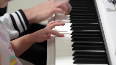 Genç bir kız ve bir adam gün içinde yan yana piyano çalarlar. Birlikte güzel müzik yapıyorlar, küçük eller daha büyük bir gruptan öğreniyor. Pratik mükemmelleştirir..