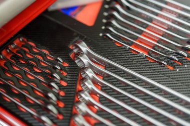 Aletler siyah ve kırmızı bir tezgaha düzgünce yerleştirilir. Çeşitli anahtarlar ve diğer aletler görülebilir. Öğleden sonra güneşinin ışığı onların parlak yüzeylerini aydınlatır..