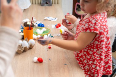 Anne ve çocuk Paskalya yumurtası boyuyor.