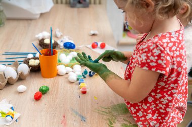 Paskalya 'da kille oynayan ve resim yapan bir kız. Çocuk yaratıcılığı. ev dekoru.
