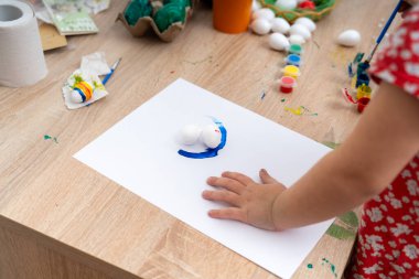 Çocuk masayı boyuyor.