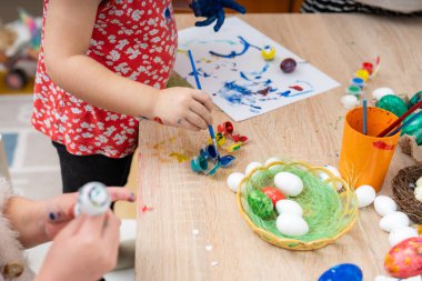 Paskalya yumurtaları boyayan küçük kız