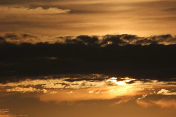 Sol por trás da faixa de nuvens — Fotografia de Stock