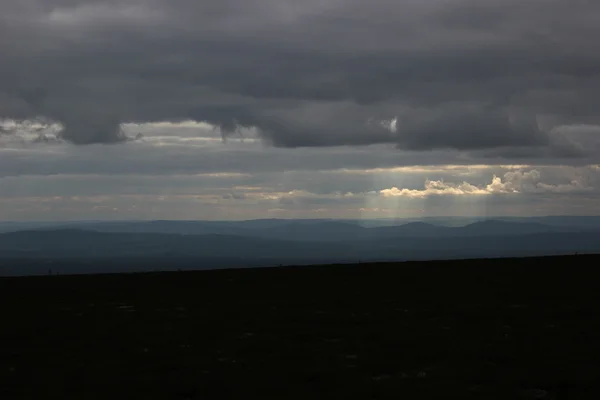 Différentes nuances de bleu et de rayons de soleil vues d'une montagne suédoise — Photo