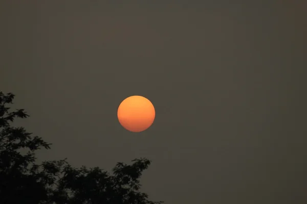 Deep orange sun in polluted sky — Stock Photo, Image