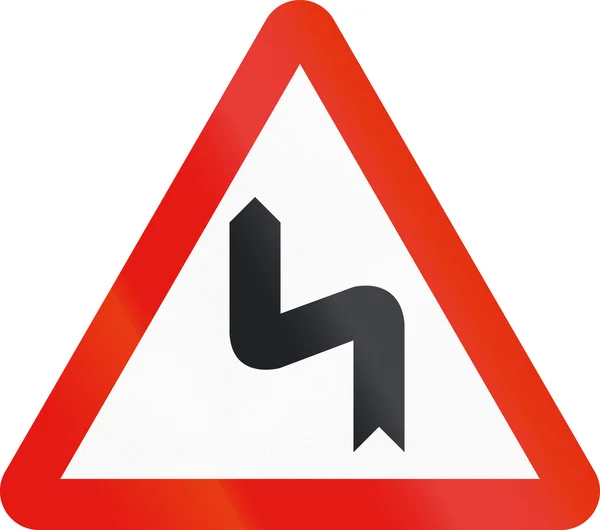 Дорожный знак используется в Испании - Опасные кривые слева — стоковое фото