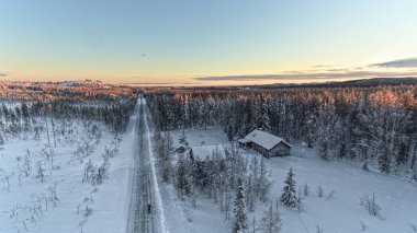 İsveç Laponya 'daki karlı yol ve çiftliğin insansız hava aracı görüntüleri..