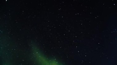 Yeşil ve menekşe kuzey ışıkları bulutlar dahil