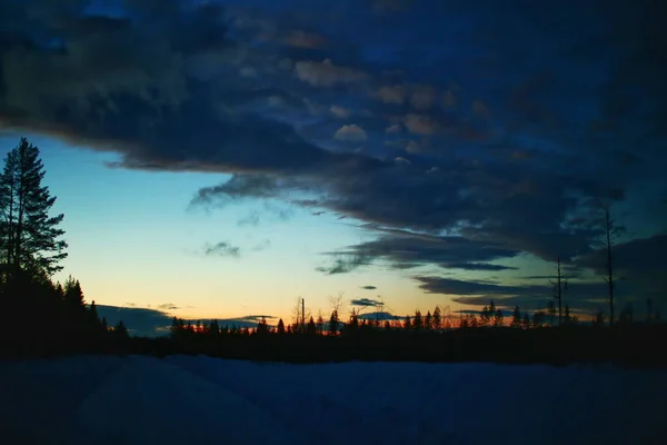 スウェーデンのラップランドの冬の道路上の夕暮れと雲 — ストック写真