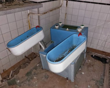 Terk edilmiş mavi leğen cihazı. Çürüme ve bozulma gösteren bir sanayi bölgesinde..