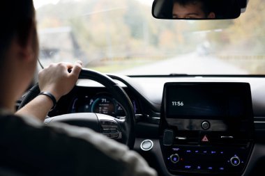 Direksiyonu yüksek hızda sürerken sıkıca tutan eller, içeriden bakıldığında, kontrol, odaklanma ve dinamik sürüş deneyimi, otomotiv ve yaşam tarzı içeriğini vurguluyor.