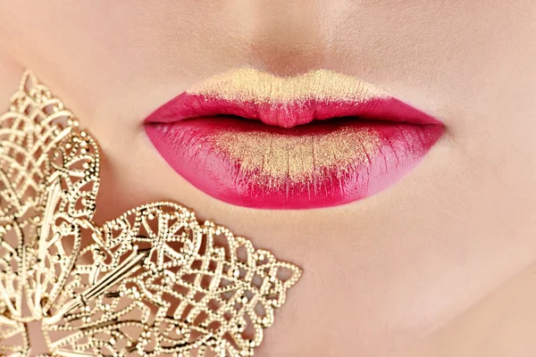 Schmuck in der Nähe goldener weiblicher Lippen — Stockfoto