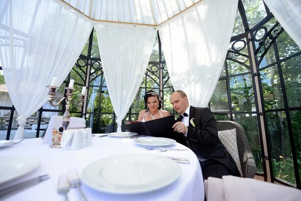 Beautiful Wedding couple reading menu — Stock Photo, Image