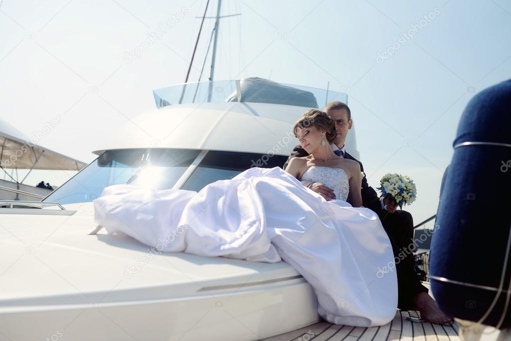 Wedding couple hugging on yacht