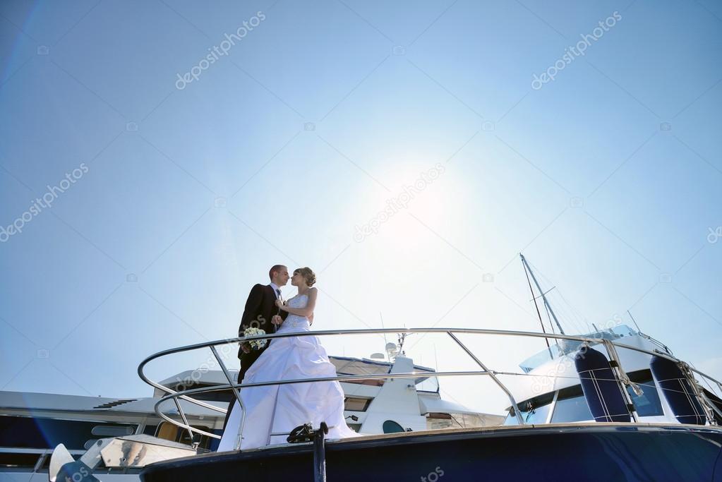 Wedding couple hugging on yacht