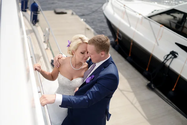 Wedding couple hugging on yacht