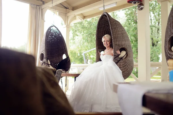 Mooie bruid in ronde rieten schommel — Stockfoto