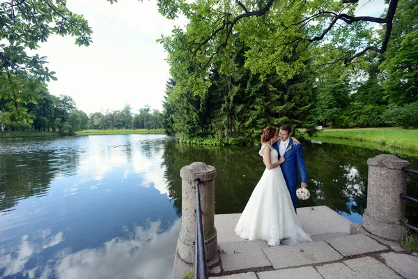 Bruidspaar knuffelen in de buurt van lake — Stockfoto