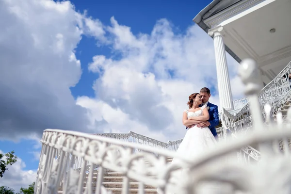 Hochzeitspaar umarmt sich auf Treppe — Stockfoto