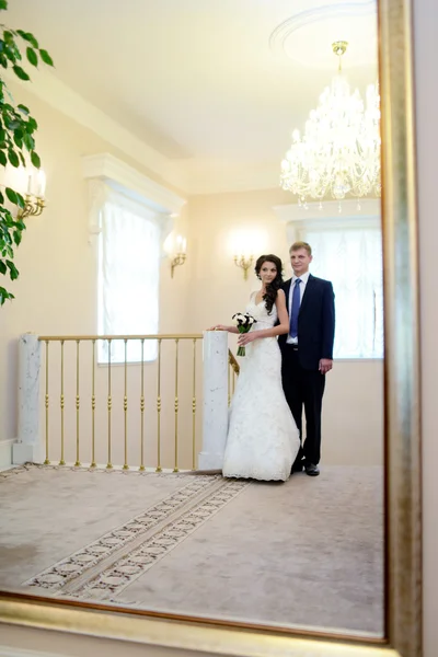Свадебная пара обнимается в элегантном интерьере — стоковое фото