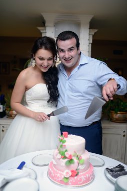 Gelin ve damat düğün pastasını kesiyor