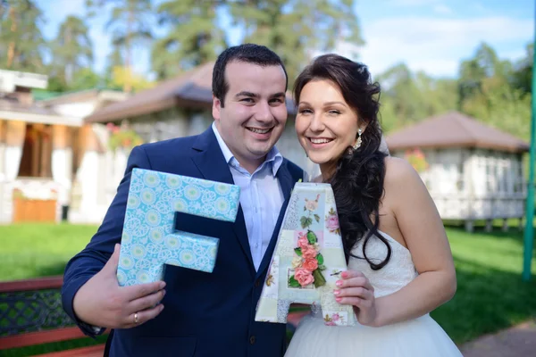 Hermosa pareja de boda sosteniendo cartas — Foto de Stock