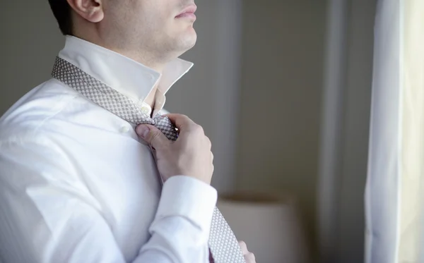 Pohledný ženich nosí kravatu — Stock fotografie