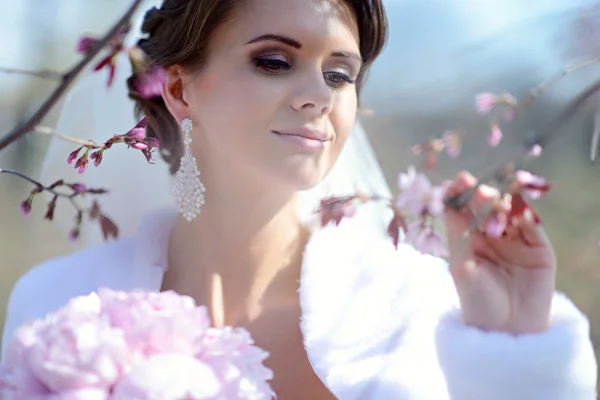 Beautiful bride in bridal gown in park — Stock Photo, Image