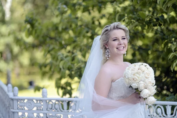 Mooie blonde bruid in park — Stockfoto