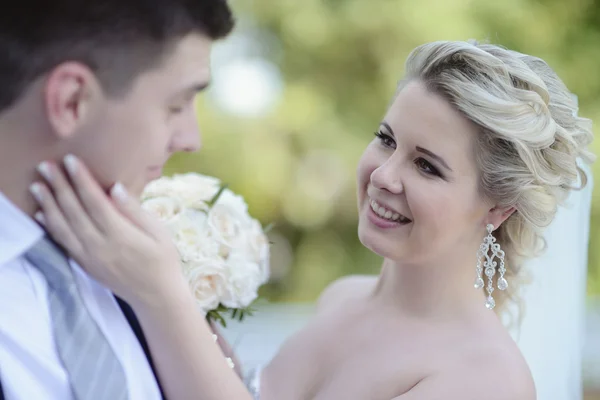 Beautiful bride and groom hugging in park — Stock Photo, Image