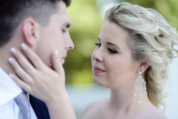 Beautiful bride and groom hugging in park — Stock Photo, Image