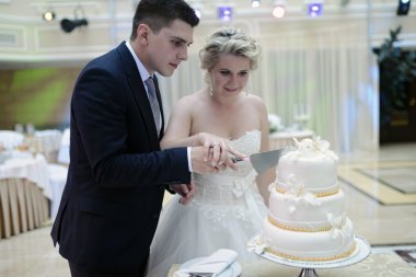 Gelin ve damat düğün pastasını kesiyor