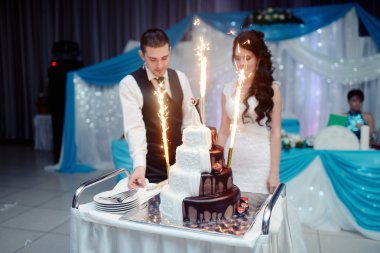 Gelin ve damat düğün pastasını kesiyor