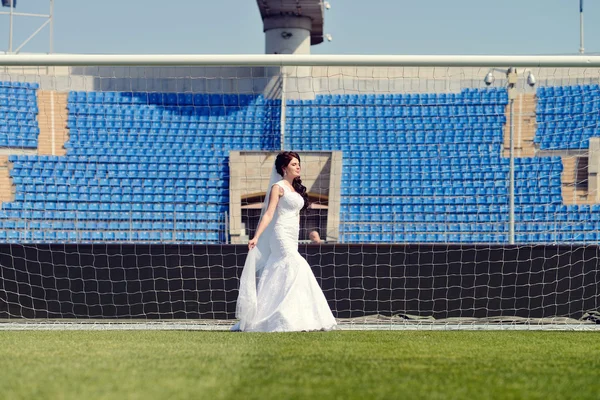 Bruid in trouwjurk op voetbalstadion — Stockfoto