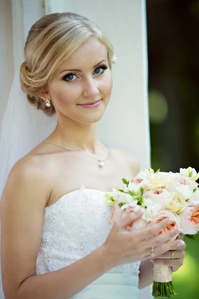 Mooie blonde bruid met boeket — Stockfoto