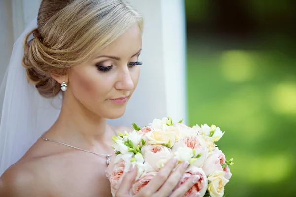 Mooie blonde bruid met boeket — Stockfoto