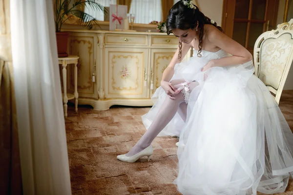 Bella sposa che indossa giarrettiera nuziale — Foto Stock