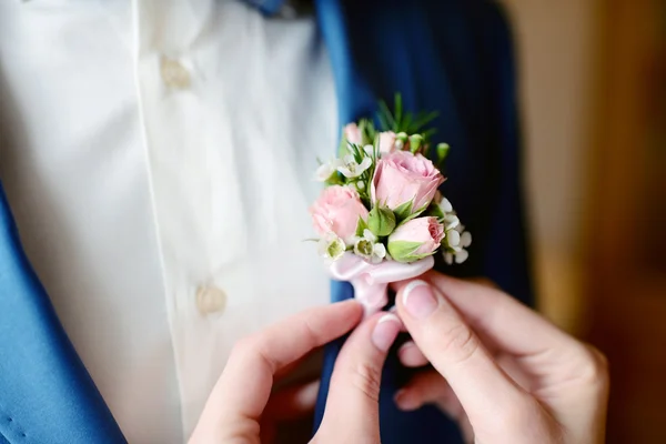 Brudgummen och bruden bär boutonniere — Stockfoto