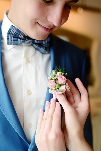 Brudgummen och bruden bär boutonniere — Stockfoto