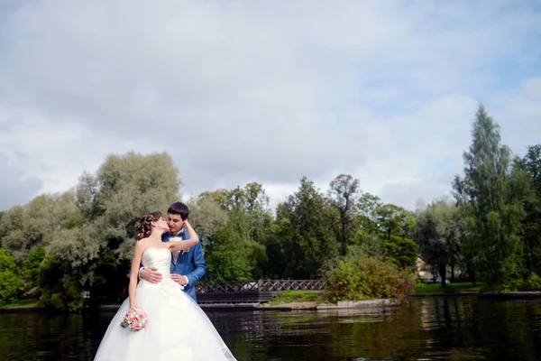 Matrimonio coppia abbracciare vicino lago — Foto Stock