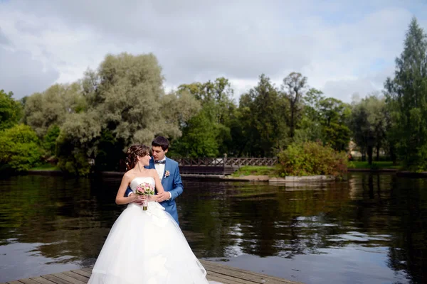 Casamento casal abraçando perto do lago — Fotografia de Stock