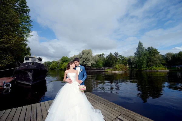 Bruidspaar knuffelen op houten pier — Stockfoto