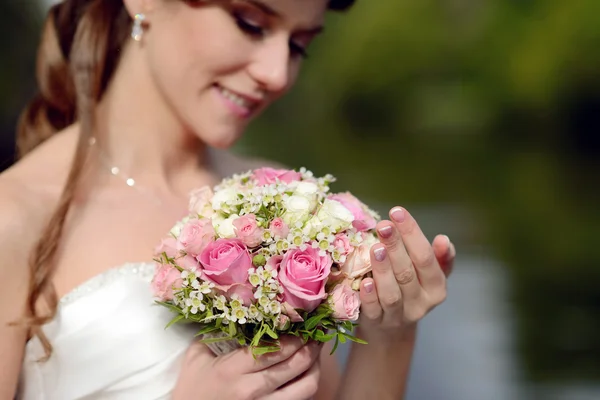 Beautiful bride with bouquet in park — Stock Photo, Image